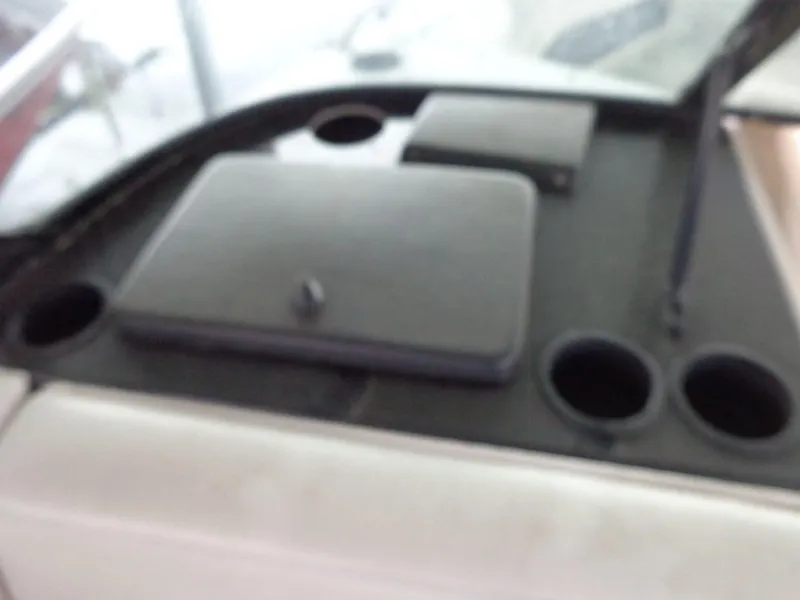 Slide: The Image of Dashboard of a 1998 Malibu Sunsetter VLX boat with cup holders and storage compartments. - 43