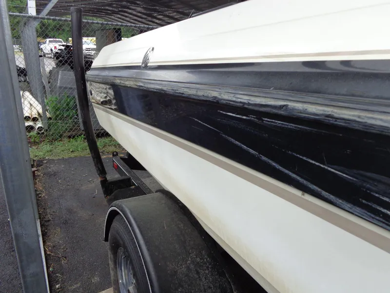 Slide: The Image of 1998 Malibu Sunsetter VLX boat on trailer, showing side view with black and white detailing. - 7