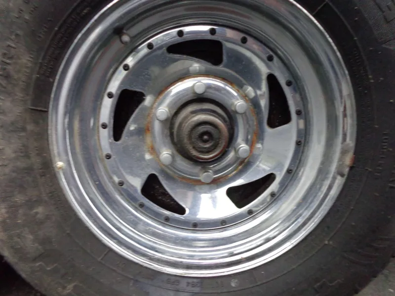 Slide: The Image of Close-up of a 1998 Malibu Sunsetter VLX chrome wheel with visible rust. - 8