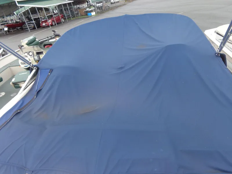 Slide: The Image of 2007 Sea Ray 200 Sundeck with blue boat cover in marina. - 24