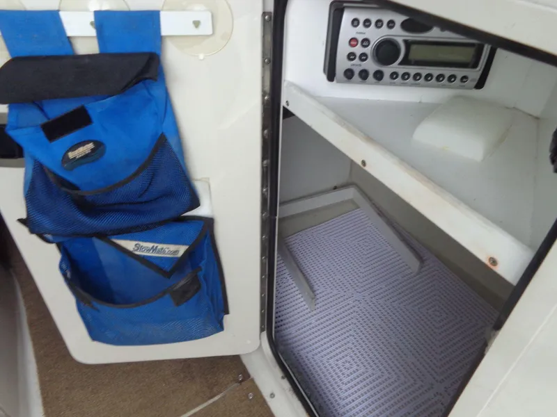 Slide: The Image of 2007 Sea Ray 200 Sundeck storage compartment with blue organizer and radio system. - 40