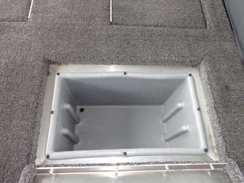 Slide: The Image of 2020 Lowe Stinger 175C boat storage compartment with gray carpeted interior. - 10