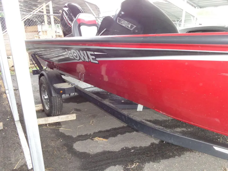 Slide: The Image of 2020 Lowe Stinger 175C red boat on trailer in storage area. - 17