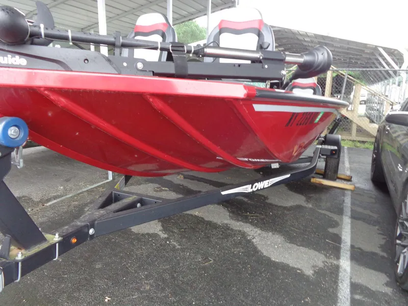 Slide: The Image of 2020 Lowe Stinger 175C red boat on trailer in parking lot. - 26