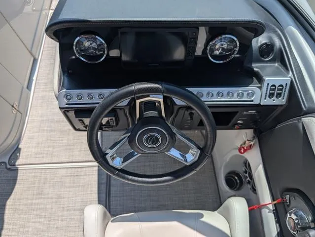 Slide: The Image of 2022 Crownline 255 SS boat dashboard with steering wheel and control panel. - 11