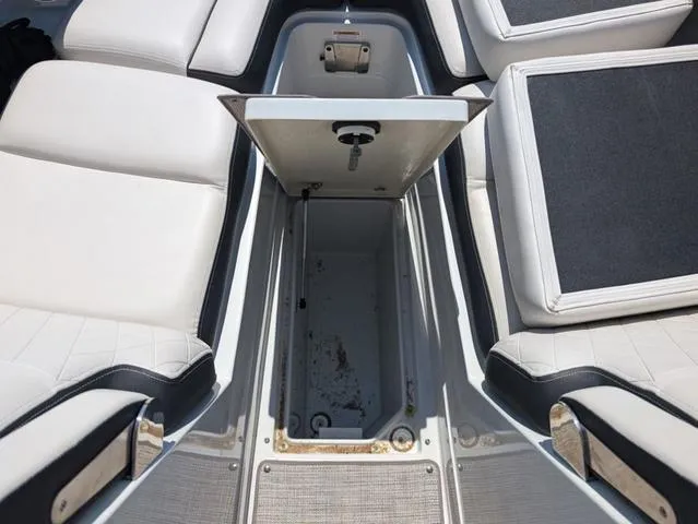 Slide: The Image of 2022 Crownline 255 SS boat interior storage compartment with white seating. - 18