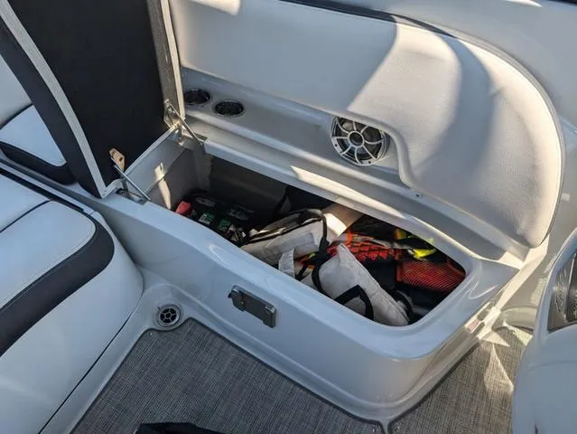 Slide: The Image of 2022 Crownline 255 SS boat storage compartment with safety gear and accessories. - 21