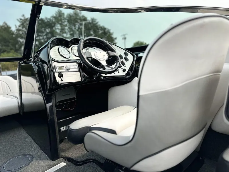 Slide: The Image of 2016 Sanger 237LTZ boat interior with sleek dashboard and white seating. - 10