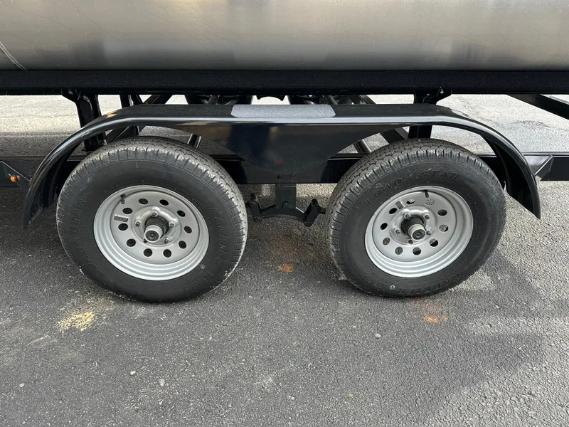 Slide: The Image of 2024 Starcraft LX 22 F trailer wheels on asphalt surface. - 5