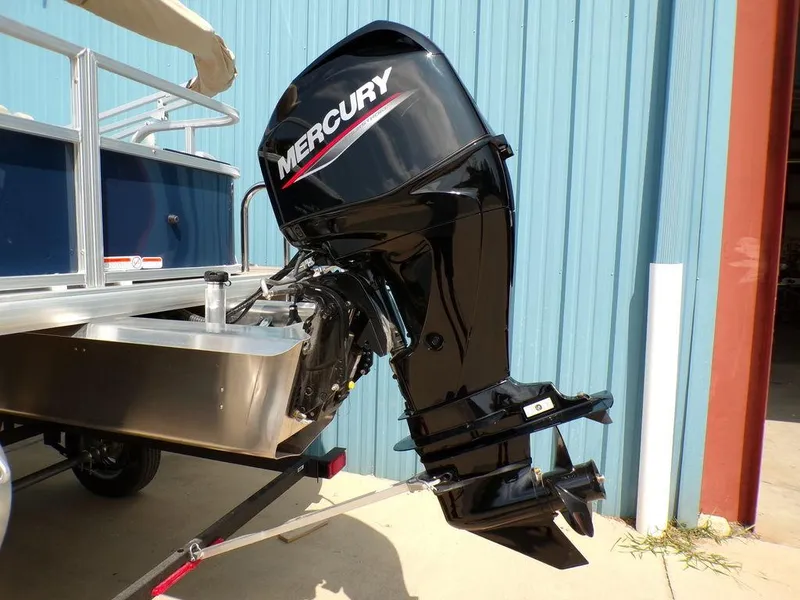 Slide: The Image of 2024 Sun Tracker BASS BUGGY® 18 DLX with Mercury outboard motor, parked near blue building. - 4