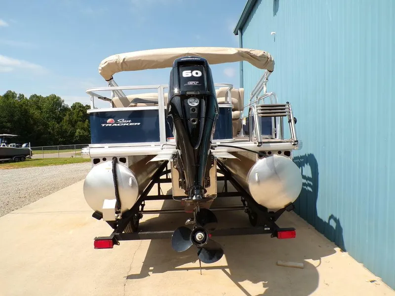 Slide: The Image of 2024 Sun Tracker BASS BUGGY® 18 DLX pontoon boat with 60 HP engine, docked outdoors. - 5