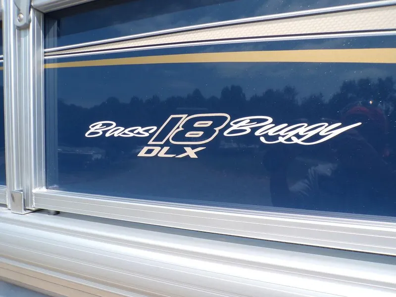 Slide: The Image of 2024 Sun Tracker BASS BUGGY® 18 DLX logo on blue boat exterior. - 9