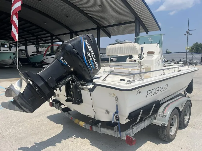 Slide: The Image of 2000 Robalo 2000 boat with Mercury outboard motor on a trailer, parked under a canopy. - 15