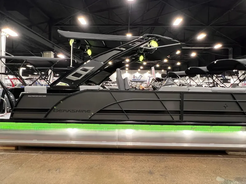 Slide: The Image of 2025 Berkshire 25RFX Roswell Arch STS Tritoon with green LED lights, showcased indoors. - 1