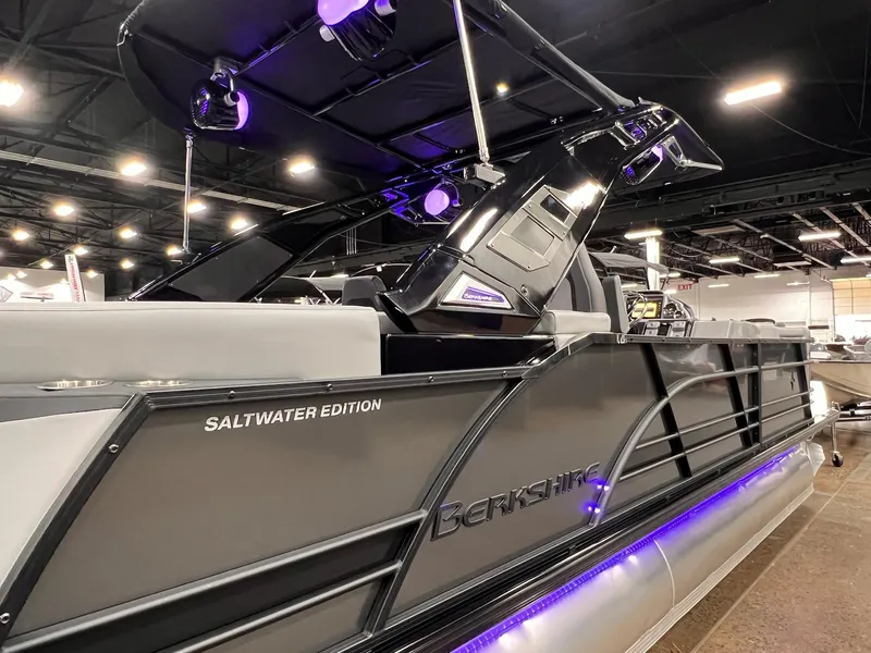 Slide: The Image of 2025 Berkshire 25RFX Roswell Arch STS Tritoon, Saltwater Edition, showcased indoors with purple lighting. - 23