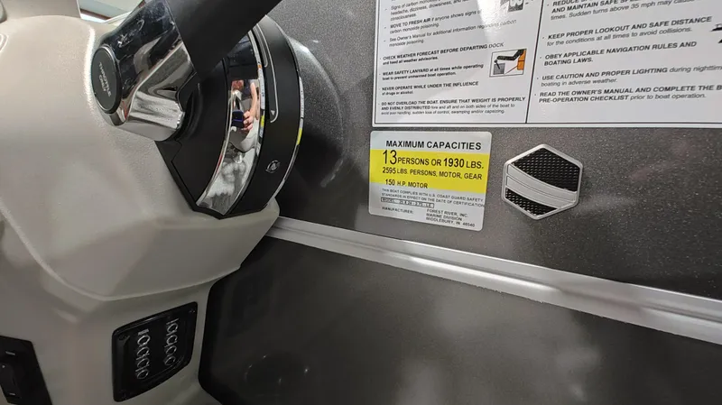 Slide: The Image of 2024 South Bay 224RS LE 2.75 boat dashboard with capacity and safety labels. - 10