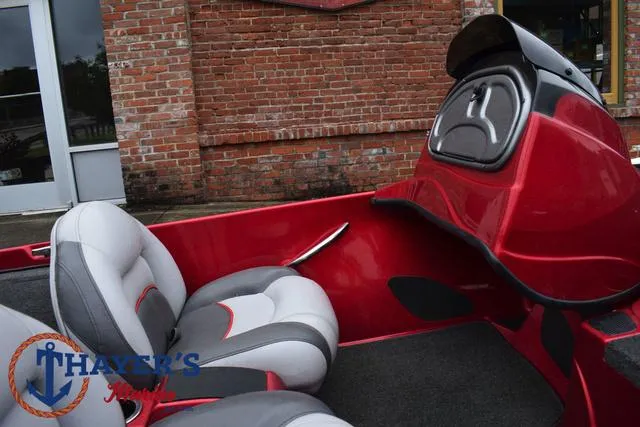 Slide: The Image of 2014 Nitro Z Series Z-6 boat interior with red and gray seating, parked by a brick wall. - 19