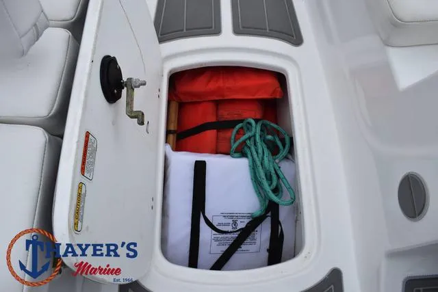 Slide: The Image of Tahoe T16 2022 boat storage compartment with safety gear and ropes. - 18