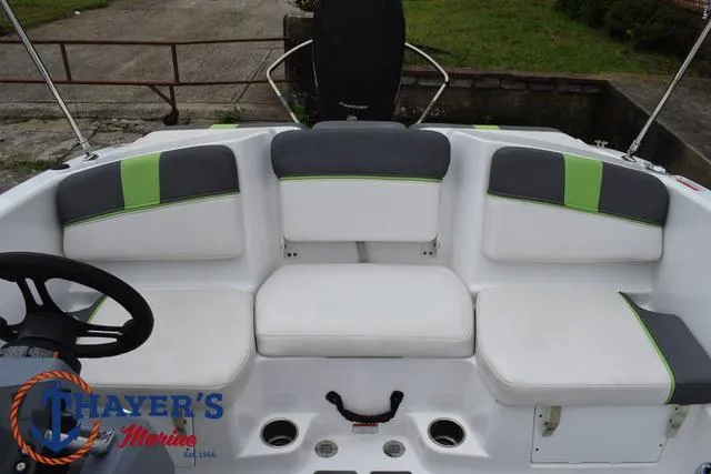 Slide: The Image of 2022 Tahoe T16 boat interior with white and green seating, steering wheel, and logo. - 28