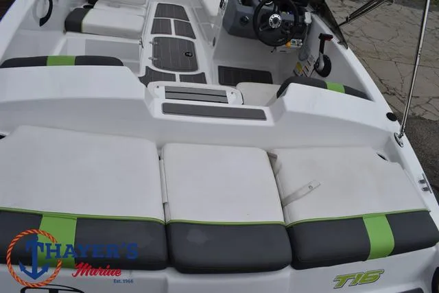 Slide: The Image of 2022 Tahoe T16 boat interior with gray and green seating, steering wheel, and Thayer's Marine logo. - 30