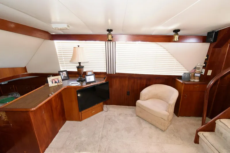 Slide: The Image of 1985 Ocean Yachts 46 Aft Cabin Motor Yacht interior with wood paneling and cozy seating area. - 15