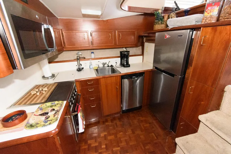 Slide: The Image of 1985 Ocean Yachts 46 Aft Cabin Motor Yacht kitchen with wood cabinetry and modern appliances. - 18