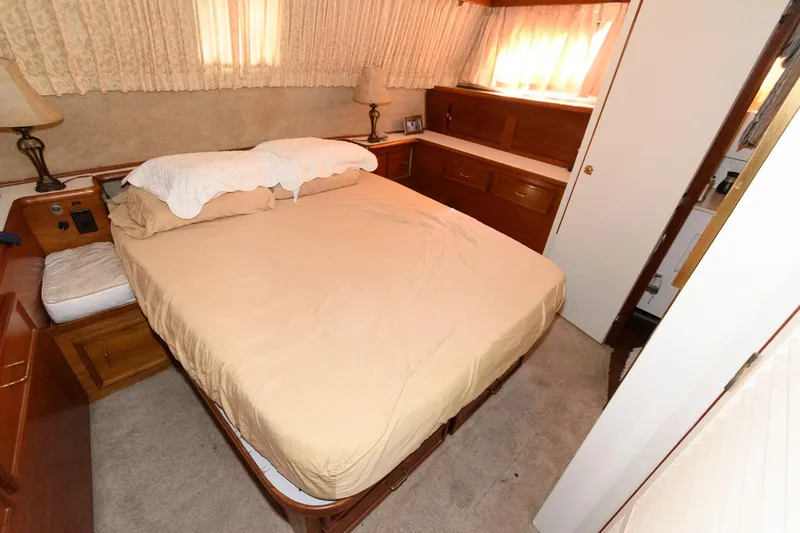 Slide: The Image of 1985 Ocean Yachts 46 Aft Cabin Motor Yacht bedroom with double bed and wooden cabinetry. - 19