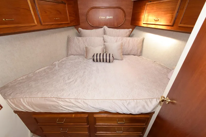 Slide: The Image of 1985 Ocean Yachts 46 Aft Cabin Motor Yacht bedroom with cozy bedding and wooden cabinetry. - 22