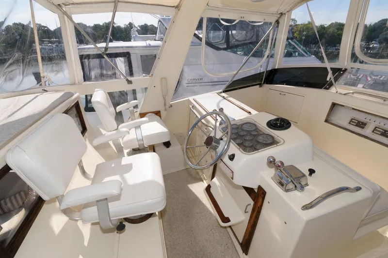 Slide: The Image of 1985 Ocean Yachts 46 Aft Cabin Motor Yacht helm with white seating and steering wheel. - 8