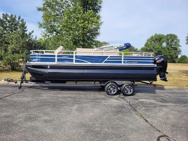 The Image of 2024 Ranger Reata 223F pontoon boat on trailer, parked outdoors. - 0