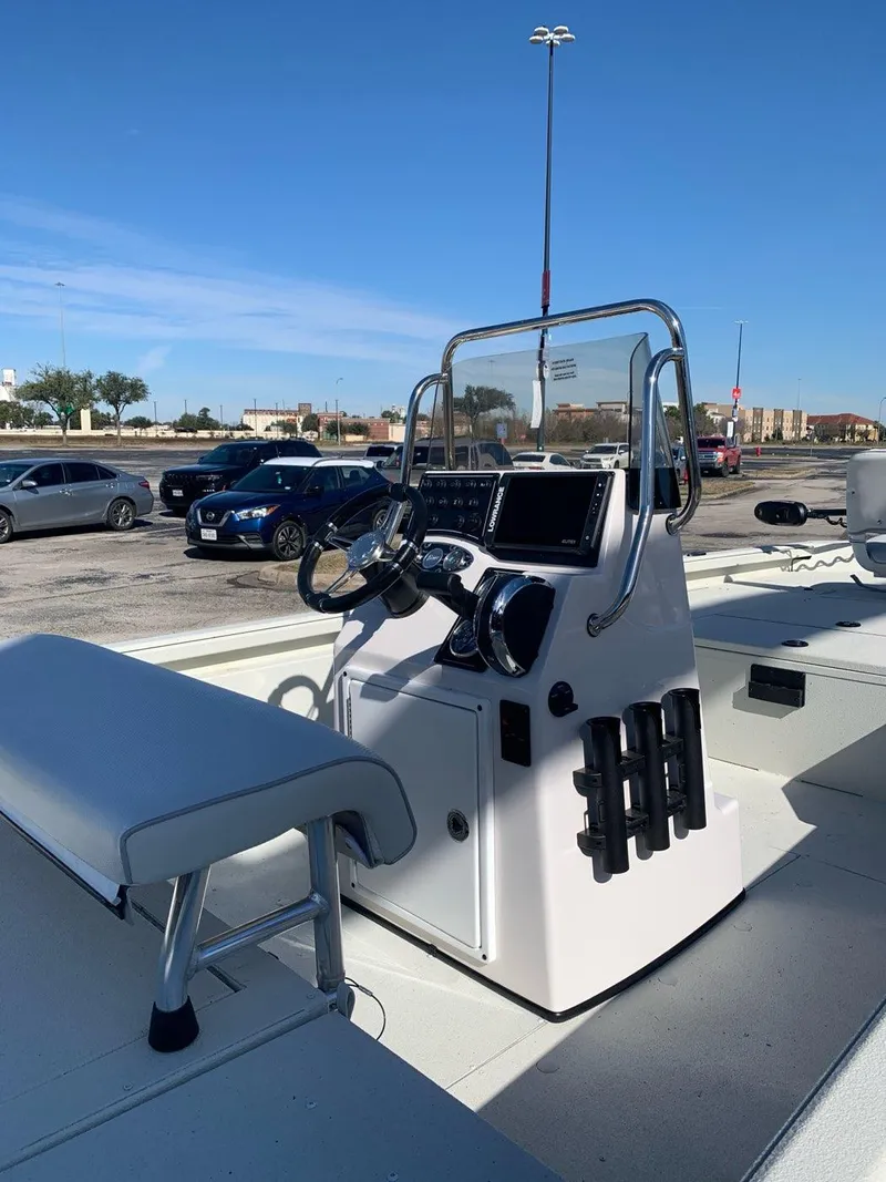 Slide: The Image of 2024 Ranger RB200 boat console with steering wheel and controls in a parking lot. - 2