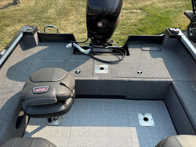 Slide: The Image of 2024 Ranger VS1782SC Angler boat interior with seating and motor, on grassy background. - 8