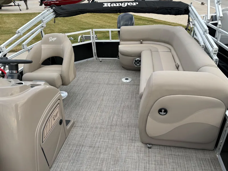 Slide: The Image of 2024 Ranger Reata 200C pontoon boat interior with beige seating and carpeted floor. - 7
