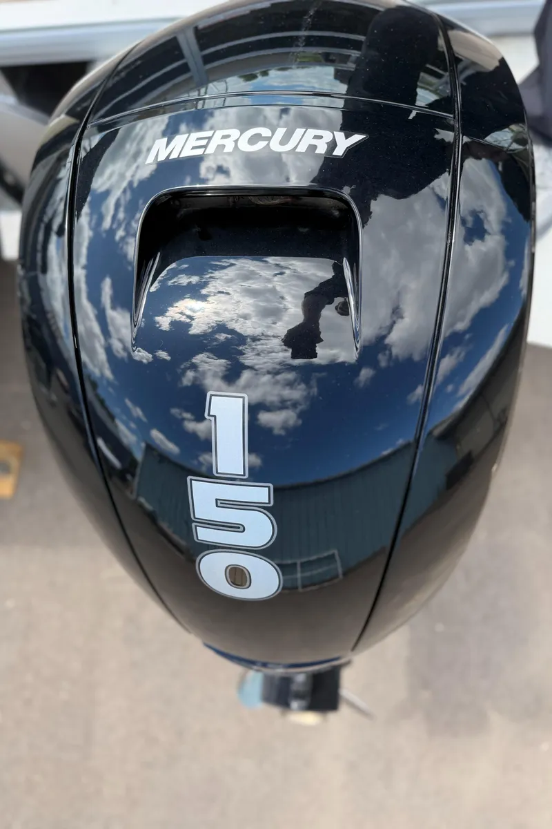 Slide: The Image of Mercury 150 outboard motor on 2024 Sun Tracker Sportfish 24 XP3, reflecting sky and clouds. - 6