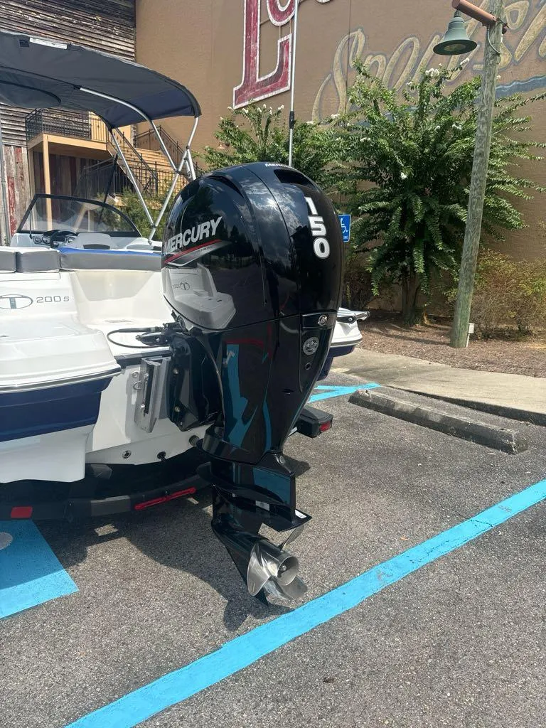Slide: The Image of 2024 Tahoe 200 S boat with Mercury 150 outboard motor in a parking area. - 1