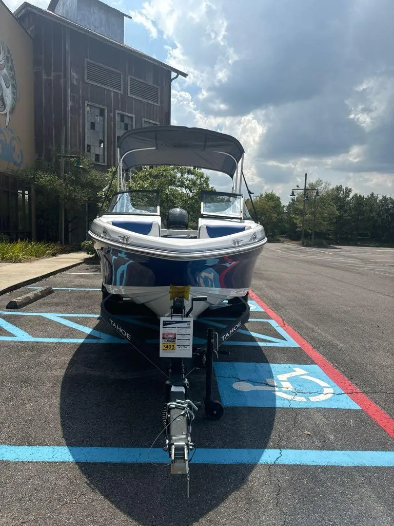 Slide: The Image of 2024 Tahoe 200 S boat parked in a lot under a cloudy sky. - 3