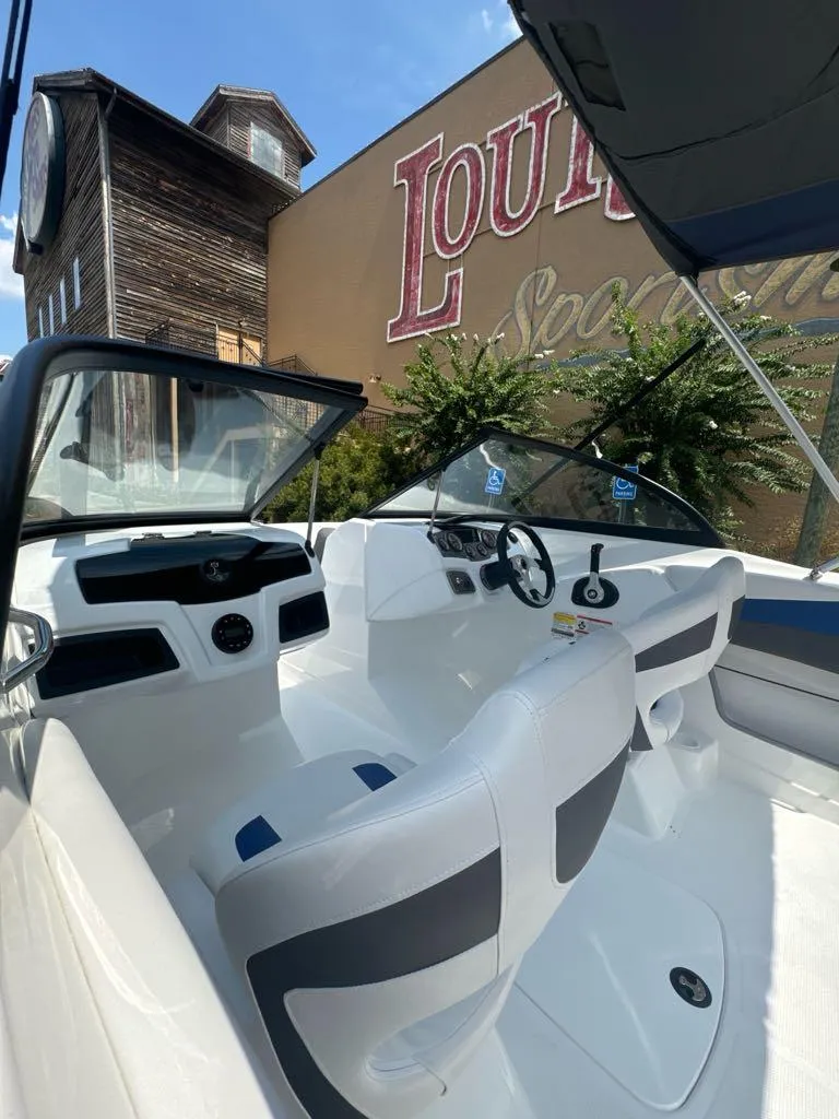 Slide: The Image of 2024 Tahoe 200 S boat interior with modern dashboard and seating, outdoor setting. - 5