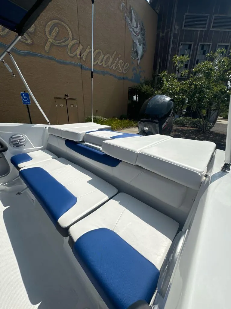 Slide: The Image of 2024 Tahoe 200 S boat with blue and white seating, parked near a mural. - 6