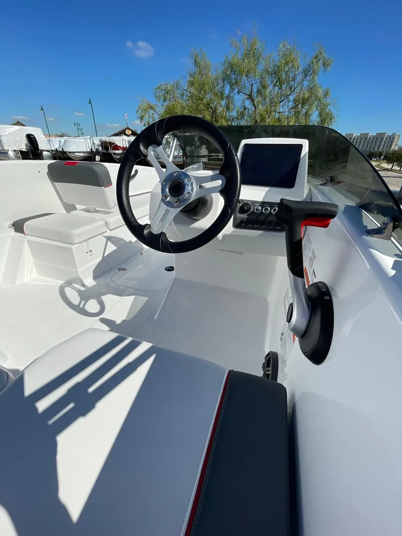 Slide: The Image of 2024 Tahoe T16 boat interior with steering wheel and dashboard under clear blue sky. - 9