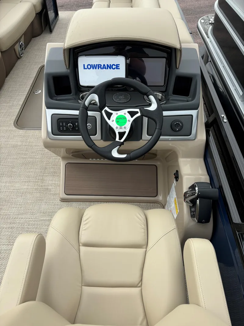 Slide: The Image of 2024 Regency 250 DL3 boat dashboard with Lowrance navigation system and beige seating. - 11