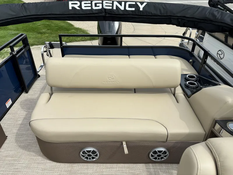 Slide: The Image of 2024 Regency 250 DL3 boat interior with beige seating and cup holders. - 13