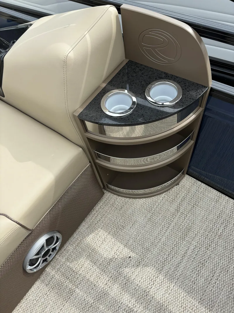 Slide: The Image of 2024 Regency 250 DL3 boat interior with cup holders and beige seating. - 15