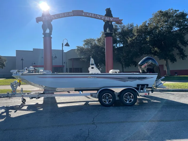 Slide: The Image of 2024 Ranger RB200 boat on trailer under sunny sky, parked near archway. - 0