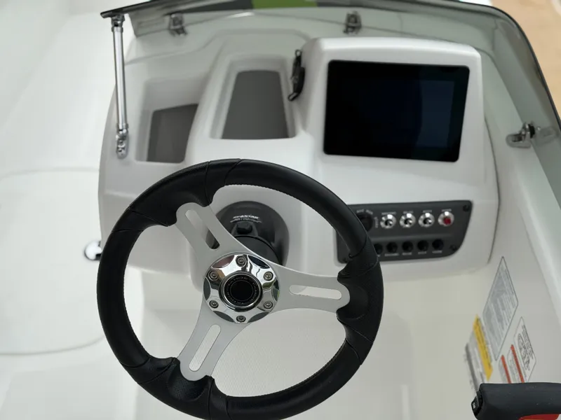 Slide: The Image of Steering wheel and dashboard of 2024 Tahoe T16 boat, featuring modern controls and display. - 10