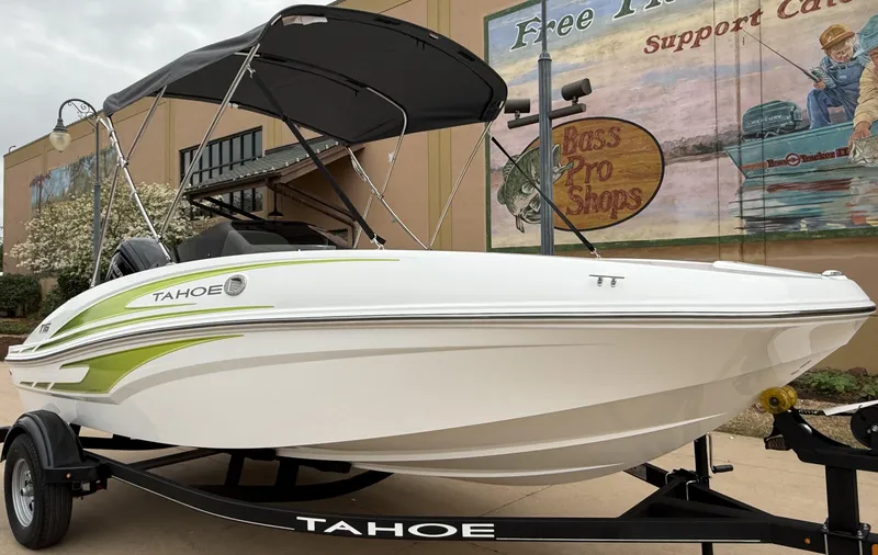 Slide: The Image of 2024 Tahoe T16 boat with canopy on trailer, displayed outdoors near a mural. - 6