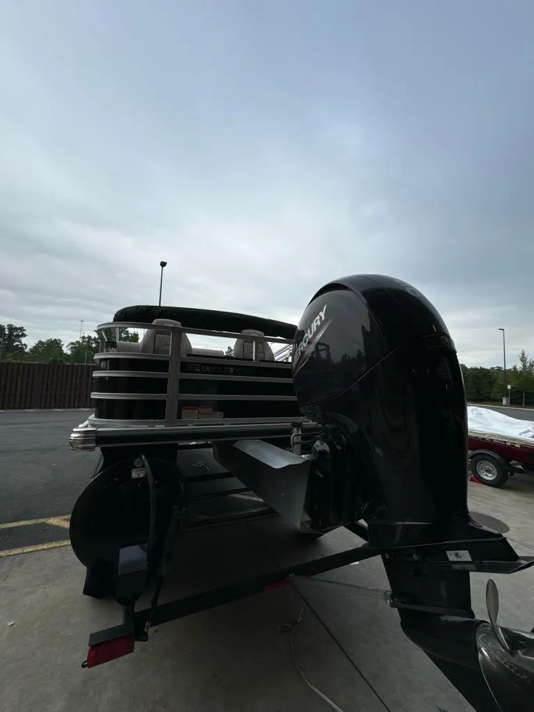 Slide: The Image of 2024 Ranger Reata 220F boat with Mercury outboard motor, parked outdoors. - 5