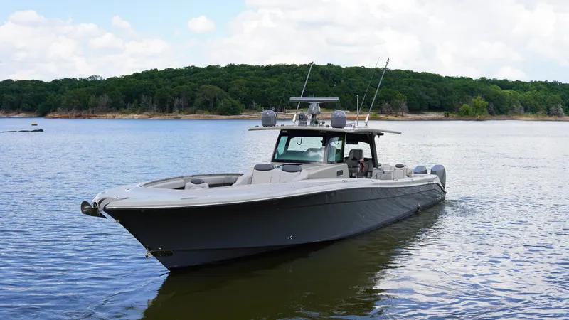 The Image of 2021 HCB 53 boat on calm lake with forested shoreline. - 0