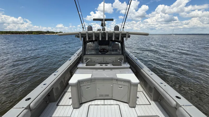 Slide: The Image of 2021 HCB 53 boat on water, featuring spacious deck and clear sky. - 10