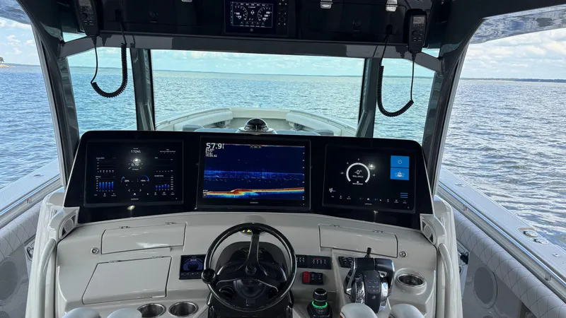 Slide: The Image of Helm of 2021 HCB 53 boat with advanced navigation displays on open water. - 26
