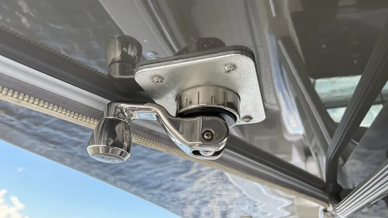 Slide: The Image of Chrome handle mechanism on a 2021 HCB 53 boat, with a clear sky background. - 34